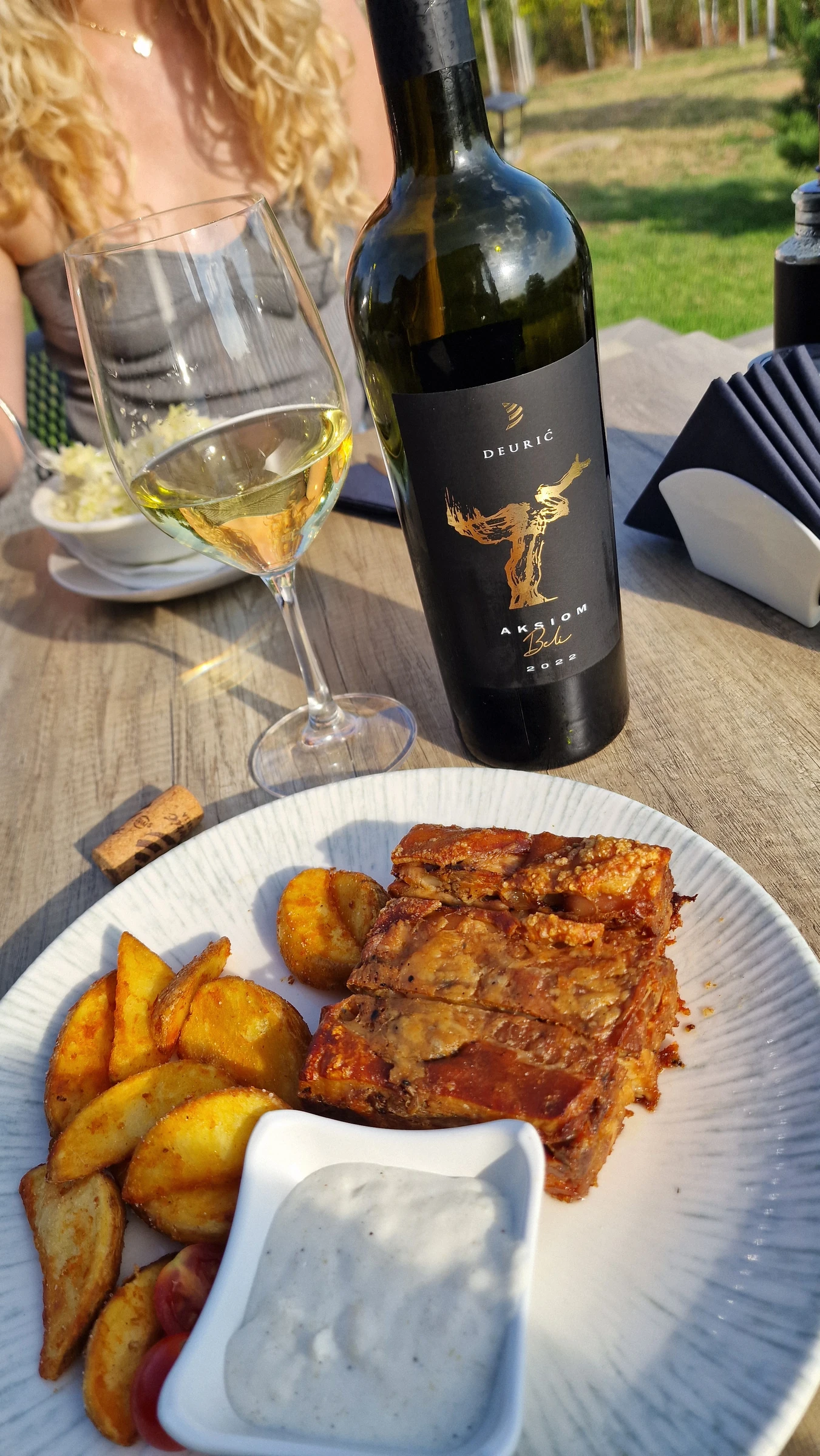 Bottle, wine glass and roast pork at Ruža vetrova