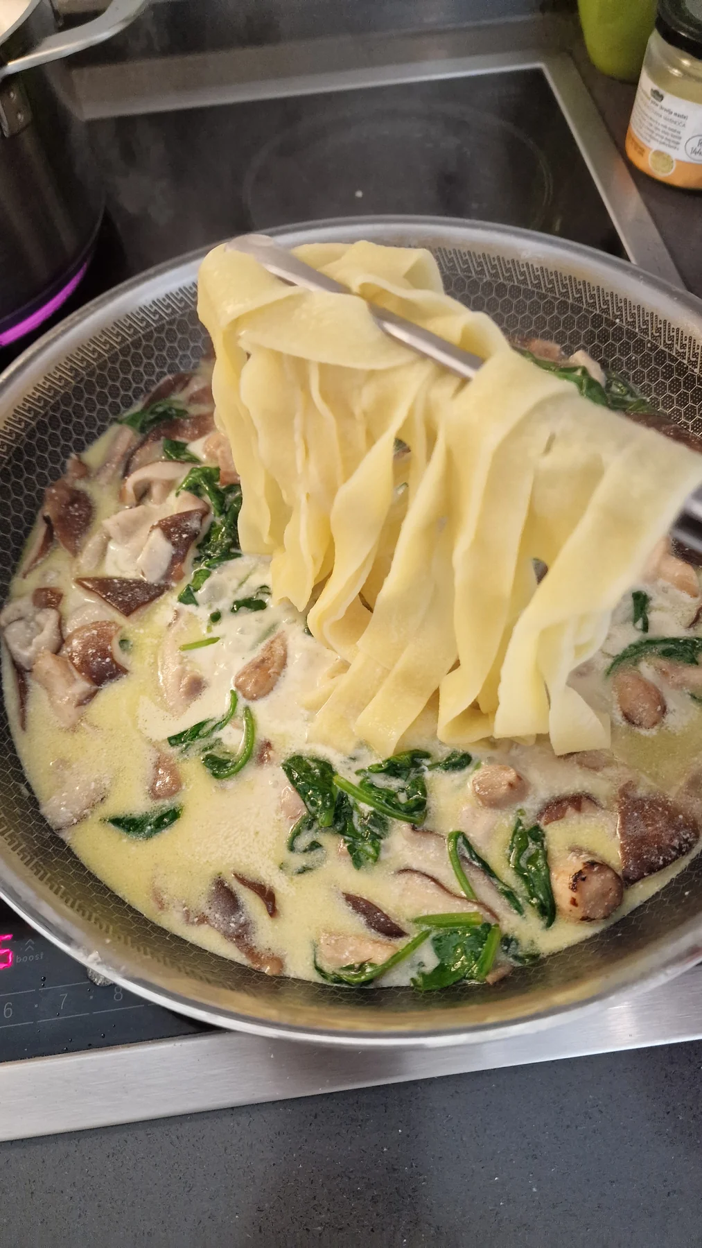 Fresh pappardelle added to mushrooms, spinach and cream