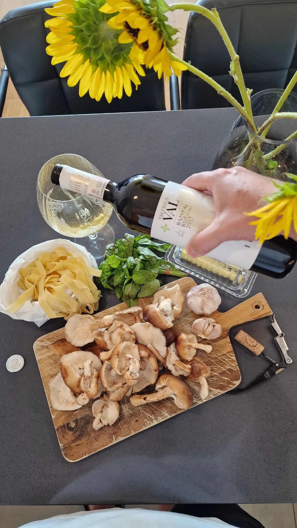 Pouring Valerius VAL Riesling beside fresh pasta and oyster mushrooms